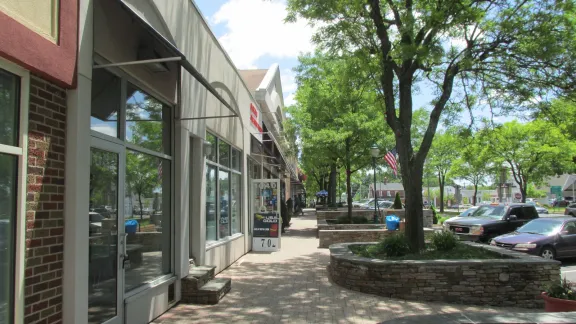 Storefronts and a tree-lined sidewalk along Main Street in the town center of Newington, Connecticut